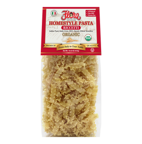 Organic Homestyle Riccetti pasta by Flora Foods, 16.02 oz, showing uncooked pasta in a bowl on a wooden surface.